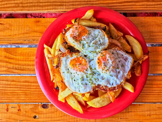 Chorrillana con huevos fritos sobre papas
