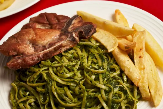 Chuleta de cerdo con tallarines verdes y papas fritas